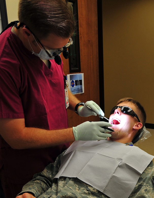 Lt. Col. (Dr.) Michael Crabtree, the 92nd Aerospace Medicine Squadron chief of dental services, performs an annual checkup on Airman 1st Class Taylor Curry, 92nd Air Refueling Wing public affairs photographer, at the dental clinic on Fairchild Air Force Base, Wash., Sept. 28, 2012. The clinic gives active duty military priority care, with limited emergency services on a stand-by basis for military dependents and retirees seeking dental care. (U.S. Air Force photo by Ninda Roberts)
