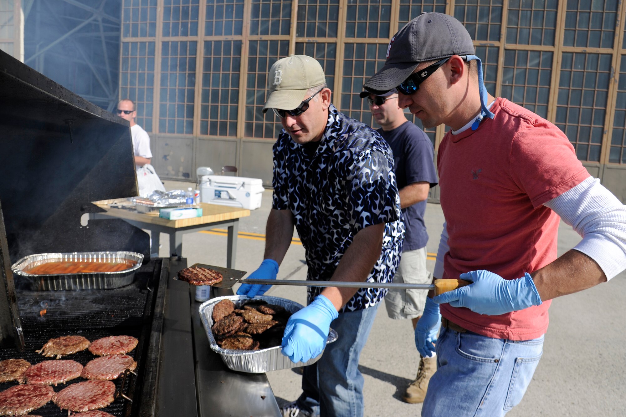 Master Sgt. Ray Malquist, the 92nd Maintenance Squadron accessories flight chief, and Master Sgt. Jon Chasse, the 92nd MXS dock section chief, grill burgers just outside hanger 2 for the burger burn held to raise funds for the Combined Federal Campaign at Fairchild Air Force Base, Wash., Sept. 29, 2012. Burgers, chips and drinks were available at the burger burn. (U.S. Air Force photo by Airman 1st Class Ryan Zeski)
