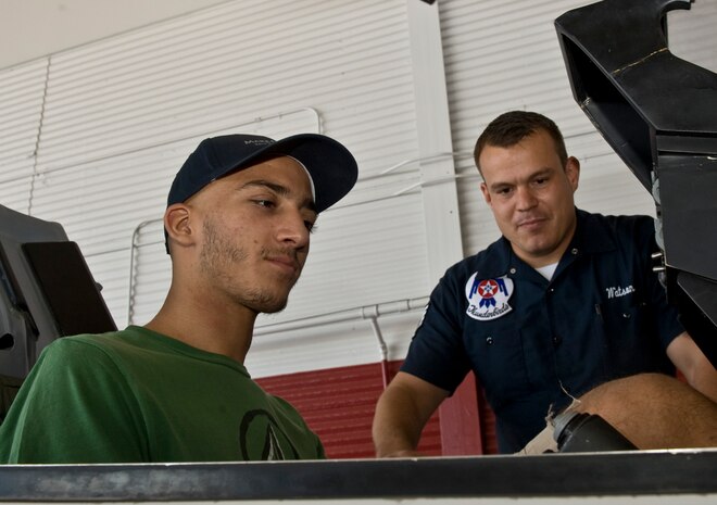 Georgios Kalevrosglou, Make-A-Wish recipient, sits inside a F-16 Fighting
Falcon simulator cockpit as Staff Sgt. Jarid Watson, USAF Aerial Demonstration team "Thunderbirds" public affairs craftsman, explains the functions of control panel Sept. 20, 2012 at Nellis Air Force Base, Nev.The Make-A-Wish Foundation worked in partnership with Nellis to fulfill Kalevrosglou's wish to be around jets and the men and women who work with them. (U.S. Air Force photo/Senior Airman Daniel Hughes)
