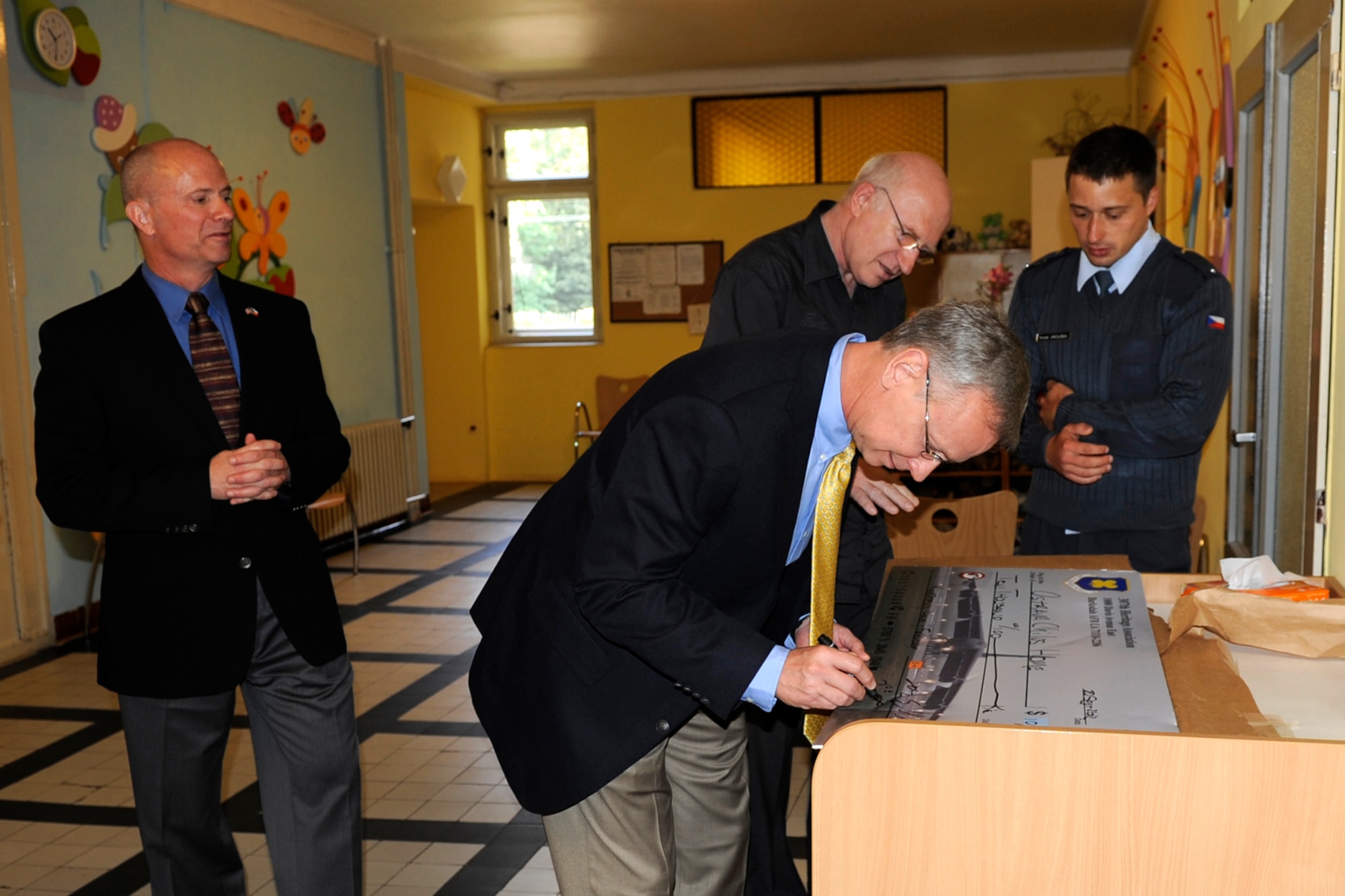 Col.  Jonathan Ellis, 307th Bomb Wing Commander, Dr. Zdenek Novotny, Ostrava  Children’s Home director and Tomas Jirousek, translator  look on as Col. Joseph Jones, 307th Bomb Wing vice commander presents a check for 10,000 Crown to the school on behalf of the 93 Bomb Squadron Heritage Association on Sept. 21, 2012. This is equivalent to approximately $500. The facility was set up in the 1920s when the city had many mine and factory workers that were impoverished.  They now have around 250 children per year come there with around 85% adopted out. (U.S. Air Force photo by Senior Master Sgt. Jessica D’Aurizio/Released)