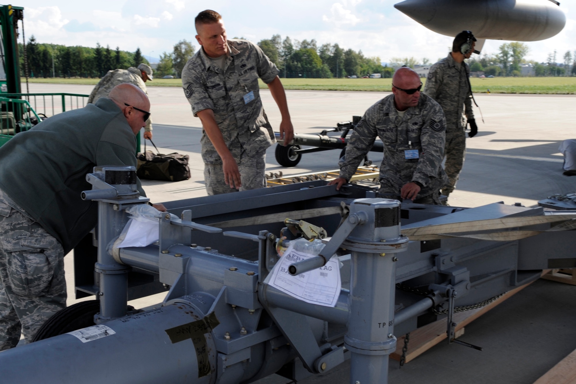 Barksdale Airmen Tech. Sgts Michael Mettenbrink, 2nd Aircraft Maintenance Squadron (middle) and Jessie Brouillette, 307th Aircraft Maintenance Squadron (right) unload a tow bar on Sept. 20, 2012, for the B-52 Stratofortress along with member of the 914th Air Wing, Niagara Falls, N.Y. from a C-130 Hercules upon their arrival to Ostrava, Czech Republic. Both aircraft participated in the NATO Days Air Show Sept. 22-23. (U.S. Air Force photo by Senior Master Sgt. Jessica D’Aurizio/Released)