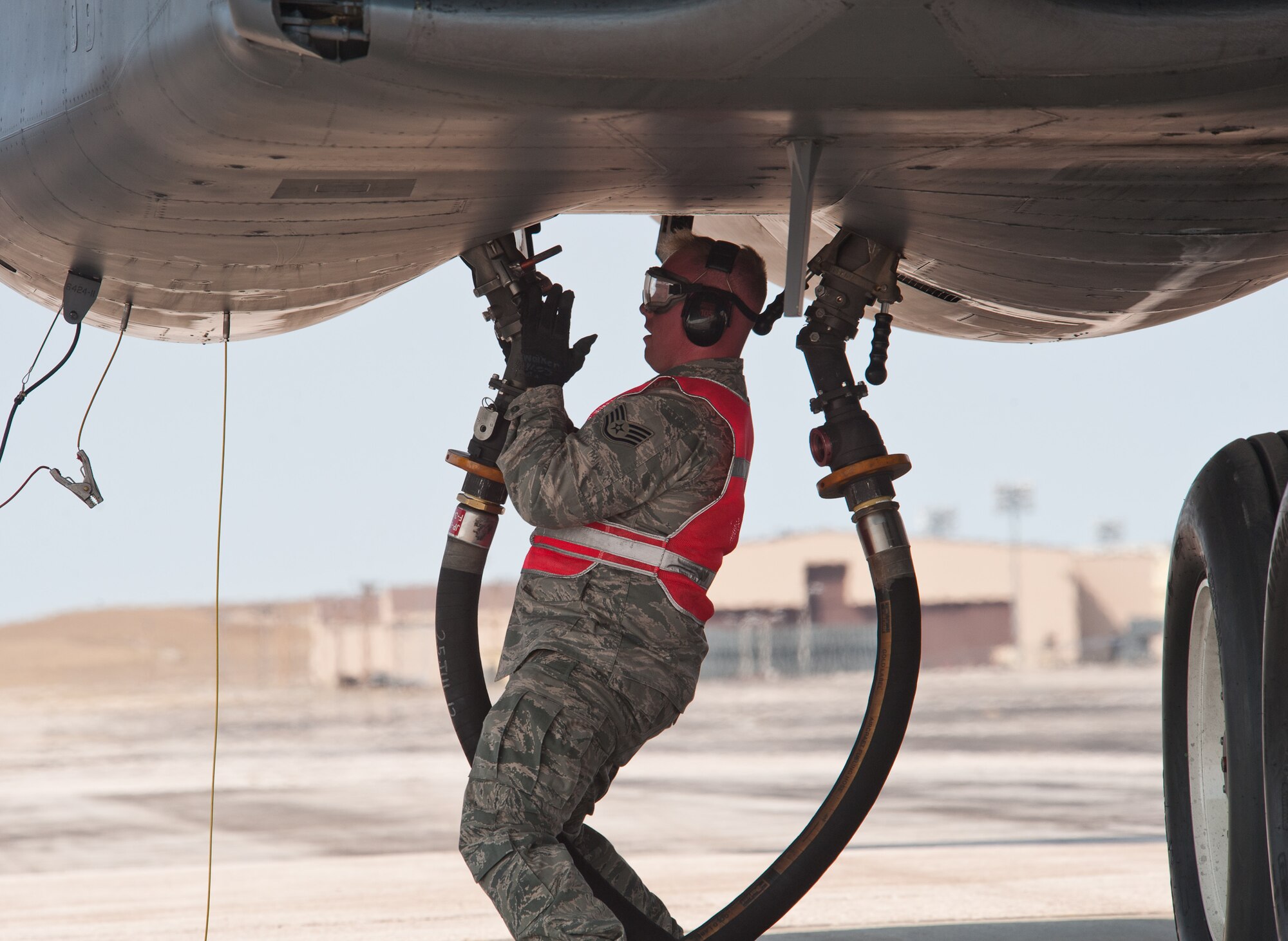 Staff Sgt. Ryan Walker, 28th Maintenance Group quality assurance inspector, connects a fuel hose to a B-1 during a hot pit refueling test and evaluation at Ellsworth Air Force Base, S.D., Sept. 25, 2012. The ability to perform hot pit refueling on base will increase the ability for base B-1s to meet sortie requirements. (U.S. Air Force photo by Airman 1st Class Alystria Maurer/Released)