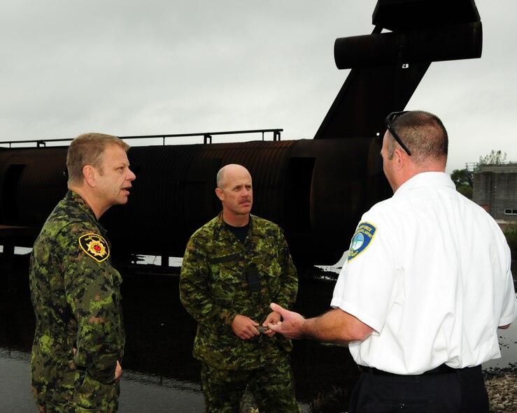 Assistant Fire Chief Aaron McLane (right), Niagara Falls Air Reserve Station Fire Emergency Services, explains operations and maintenance of the USAF aircraft live-fire training facility to Major Rick Dunning (center), 1 Canadian Air Division Fire Marshall for the Royal Canadian Air Force and Warrant Officer Ron Johnson, 8 Wing Canadian Forces Base Trenton, Platoon Fire Chief on September 26, 2012 at the Niagara Falls Air Reserve Station, N.Y.  The Canadians were here to do a comparative analysis between what the U.S. Air Force is using to train their firefighters compared to what Canadian Forces have. (U.S. Air Force photo by Peter Borys)