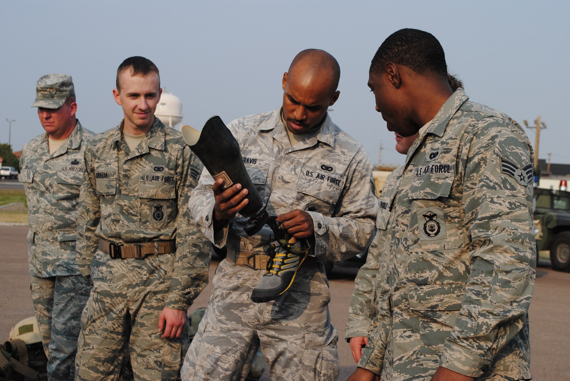 Senior Airman Michael Travis, 341st Security Forces Group Tactical Response Force member, center, holds Salvador Gonzales’ prosthetic leg as other TRF members look on. Gonzalez was deployed in Ramadi, Iraq, when he lost part of his leg after a direct roadside bomb hit his Humvee in 2004. (U.S. Air Force photo/Airman 1st Class Katrina Heikkinen)