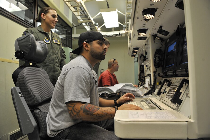 2nd Lt. Stephanie Guenther, 341st Operations Support Squadron ICBM instructor combat crew commander, left, shows Salvador Gonzalez the inside of the Missile Procedures Trainer on Sept. 25. Gonzalez and Daniel Gilyeat, both U.S. Marine Corps wounded veterans, visited Malmstrom Air Force Base as part of the American300 Gunners Tour. (U.S. Air Force photo/John Turner) 