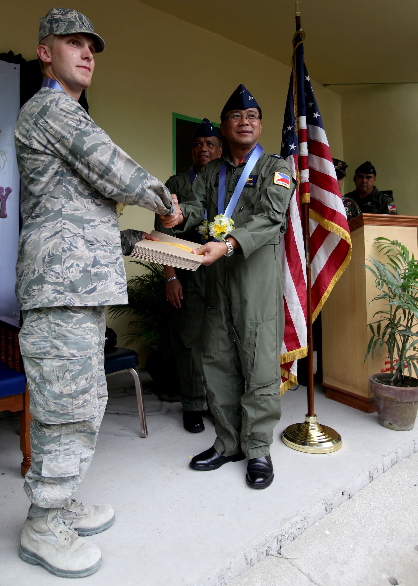 U.S. Air Force 1stLT Andrew Mcperson recieves letters
of appreciation to him and his fellow Airmen from
Republic of the Philippines Air Force MGen Ricardo
Banayat during a dedication ceremony at Clark Air
Force Base, Republic of the Philippines on September
20, 2012. U.S. Air Force Civil Engineering Squad 647
out of Joint Base Pearl Harbor teamed up with the
Republic of the Philippines Air Force to build an
addition onto a local schoolhouse before dedicating it to
the community. The U.S. military and Republic of the
Philippines military work together to strengthen
interoperability between the Philippine and U.S.
government. (U.S. Marine Corps photo by LCpl Katelyn
Hunter/Released).