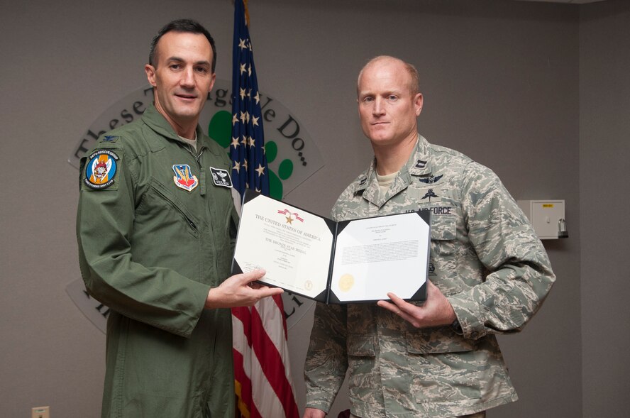 U.S. Air Force Col. Steven Gregg, 347th Rescue Group Commander, presents the Bronze Star Medal to Capt. Timothy James, 38th Rescue Squadron bravo flight commander at Moody Air Force Base, Ga., Sept. 21, 2012. James was one of three Airmen from the 347th RQG that received the Bronze Star  Medal for their hard work and dedication while deployed  at Camp Bastian, Afghanistan. (U.S. Air Force photo by Airman 1st Class Paul Francis/Released)

