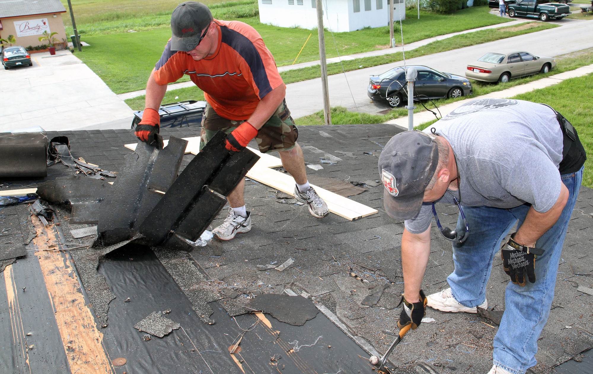 From left to right: Special Operations Command South servicemembers, Air Force Tech. Sgt. Greg Sowinski and Army Lt. Col. Stewart Mason take off old roof shingles from St. Matthews Baptist Church in Florida City, Fla., Sept. 18, as part of a weeklong project to help fix the deteriorated roof. SOCSOUTH, 482nd Fighter Wing, Homestead Job Corps and  several organizations were involved in helping repair the 60-year-old building as part of the community outreach program where military members assigned to Homestead Air Reserve Base, Fla., help residents in the surrounding areas. (Department of Defense photo by Sgt. 1st Class Alex Licea, Special Operations Command South Public Affairs Office)
