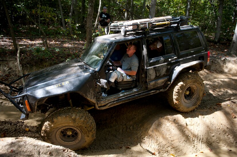 Army Sgt. James Nickelson navigates a jeep through rough terrain while Murphy looks out a window during an off-road event in Gore, Va., Sept. 15, 2012. Nickelson is assigned to Battle Company, Warrior Transition Battalion, Bethesda, Md. (U.S. Air Force photo/Val Gempis)