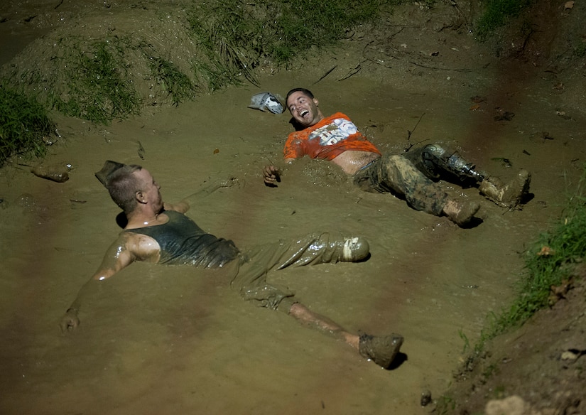 Army Sgt. James Nickelson, left, and U.S. Marine Corps Lance Cpl. John Patterson shares a laugh as they lie in a mud pit during a mud bogging competition of the Big Dog Off-Road event in Gore, Va., Sept. 15, 2012. Nickelson is with Battle Company, Warrior Transition Battalion, Bethesda, Md. and Patterson is with the 3rd Battalion, 9th Marine Regiment, Camp Lejeune, N.C. (U.S. Air Force photo/Val Gempis)