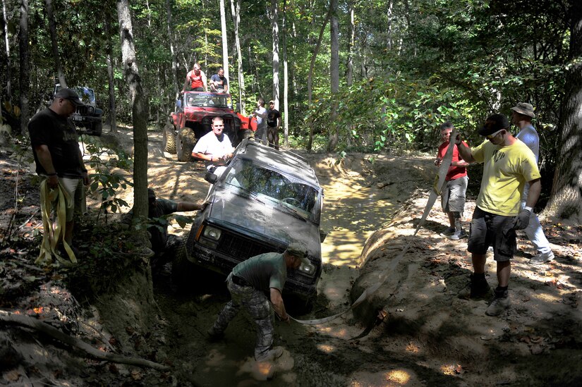 Staff Sgt. John Purser, right, together with wounded warriors and volunteers prepare to pull a jeep out of a ditch during an off-road event in Gore, Va., Sept. 15, 2012. Purser, who is the president of 4 Wheel To Heal, is assigned to the command post of the 113th Wing, Joint Base Andrews, Md. (U.S. Air Force photo/Val Gempis)