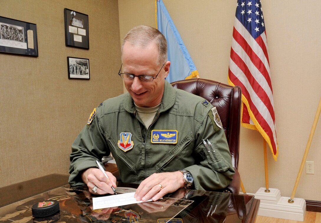 Col. Mark Weatherington, 28th Bomb Wing commander, signs his Combined Federal Campaign donation form in his office at the 28th Bomb Wing Headquarters building at Ellsworth Air Force Base, S.D., Sept. 28, 2012. The Combined Federal Campaign gives donators the choice to give to any local, national or international charity by simply filling out a donation form and giving it to their designated CFC representative or to the nearest CFC office. (U.S. Air Force photo by Airman 1st Class Anania Tekurio/Released)