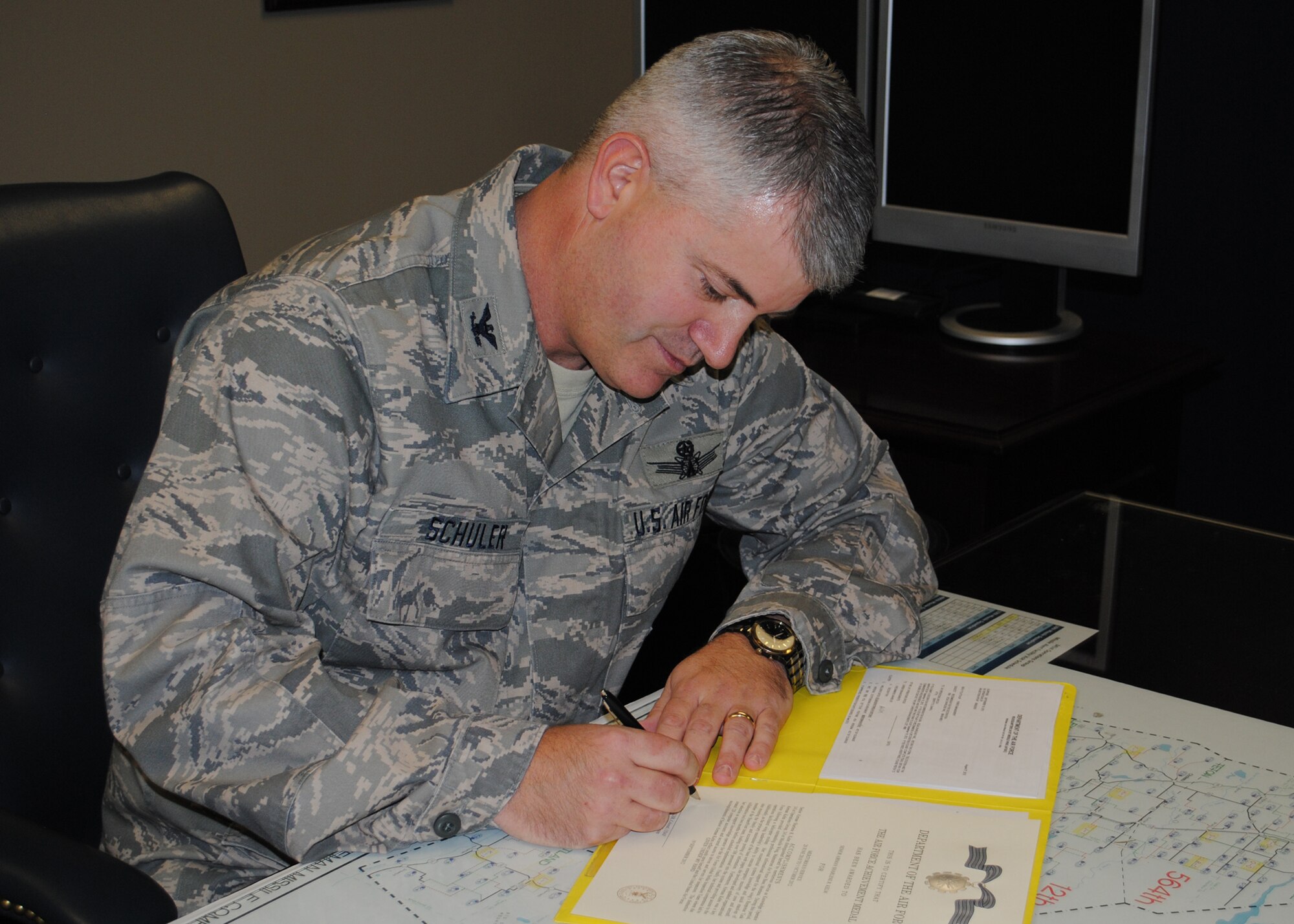 Schuler finishes up some paperwork at his desk.  Schuler took over leadership of the 341st OG on July 16 and has since been enjoying the opportunity to take care of his Airmen.  (U.S. Air Force photo/Airman 1st Class Cortney Paxton)
