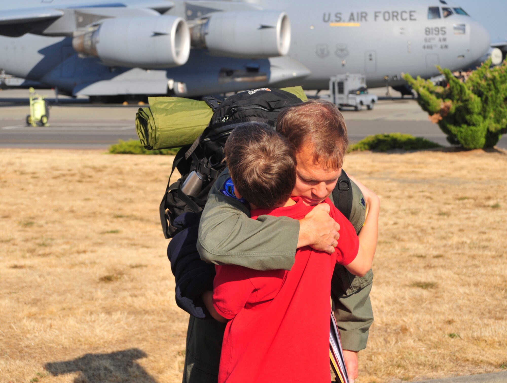 Lt. Col. Chad Marien, 7th Airlift Squadron member, hugs his son as he prepares to board the aircraft at Joint Base Lewis-McChord, Wash., Sept. 26, 2012, before heading out for a 60-day deployment in support of Operations Enduring Freedom, New Dawn, Odyssey Dawn and Combined Joint Task Force-Horn of Africa His unit is accompanied by Airmen from the 446th Airlift Wing and others from Elmendorf Air Force Base, Alaska, and Joint Base Pearl Harbor-Hickam, Hawaii.  (U.S. Air Force photo/Master Sgt. Todd Wivell) 