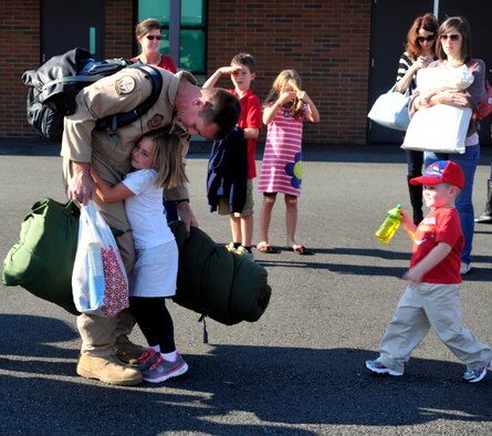 Lt. Col. William Mickley, 7th Airlift Squadron commander, hugs his children as he departs the squadron at Joint Base Lewis-McChord, Wash., Sept. 26, 2012, before heading out for a 60-day deployment in support of Operations Enduring Freedom, New Dawn, Odyssey Dawn and Combined Joint Task Force-Horn of Africa.The deployed Airmen will take over operations of the 817th Expeditionary Airlift Squadron. (U.S. Air Force photo/Master Sgt. Todd Wivell) 

