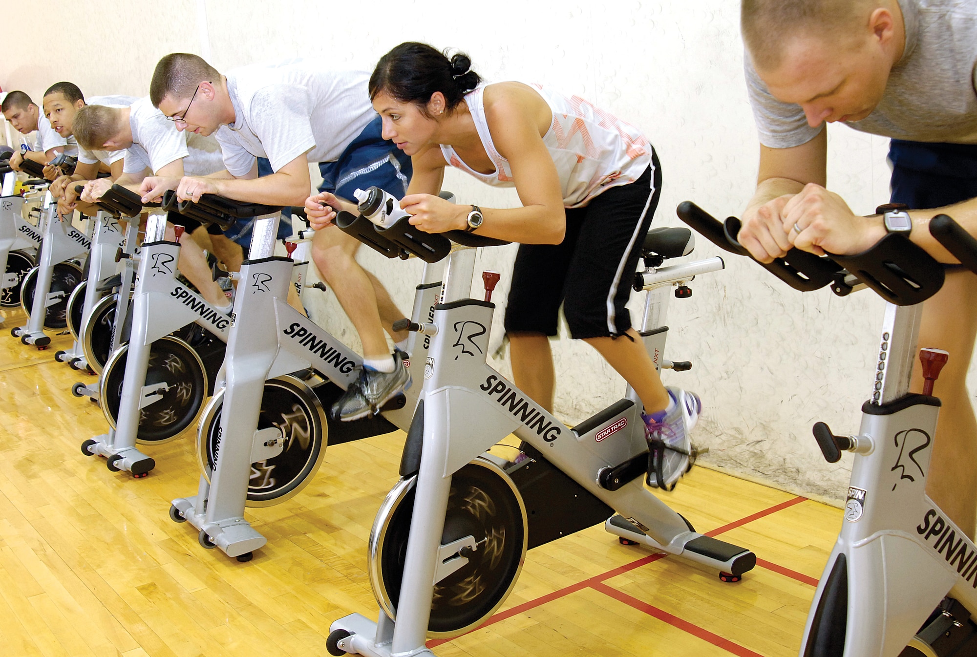 Traci Fuhrman, a 72nd Aerospace Medicine Squadron exercise physiologist, leads 17 Airmen from the 3rd Combat Communications Group through a one-hour high intensity class Sept. 25 in the Annex Gym, Bldg. 216. Nothing like riding a bike, the twice weekly aerobic workout is partnered with three days of running for a research project focused on improving physical training test scores. (Air Force photo by Margo Wright)