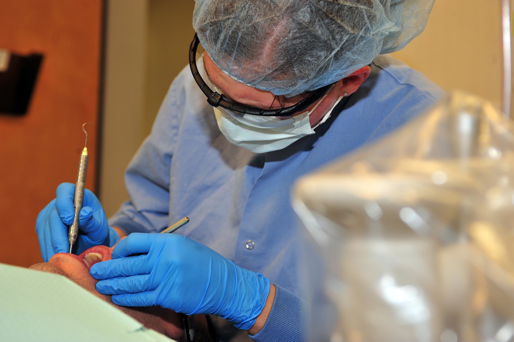 U.S. Air Force Staff Sgt. Cami Richards, 355th Dental Squadron dental assistant, cleans the teeth of her patient on Davis-Monthan Air Force Base, Ariz., Sept. 25, 2012. The dental clinic sees about seven thousand patients per year. (U.S. Air Force photo by Airman 1st Class Josh Slavin/Released)