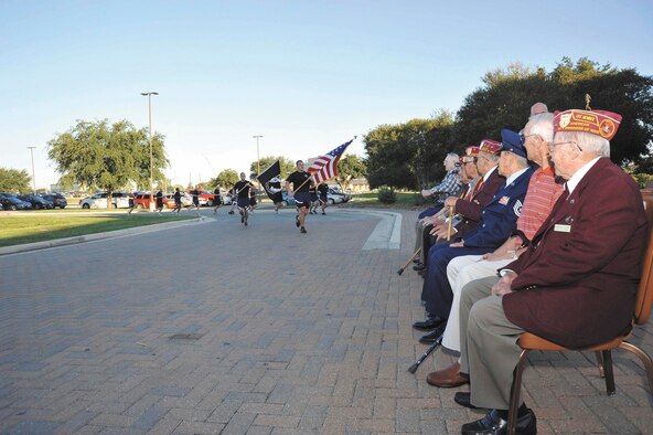 Former prisoners of war who were invited to participate in POW/MIA Recognition
Day activities watch as Airmen carry POW/MIA batons during the 37th Training Wing’s fourth annual POW/MIA 24-hour vigil run Sept. 21 at Joint San Antonio-Lackland. (U.S. Air Force photo/Alan Boedeker)

