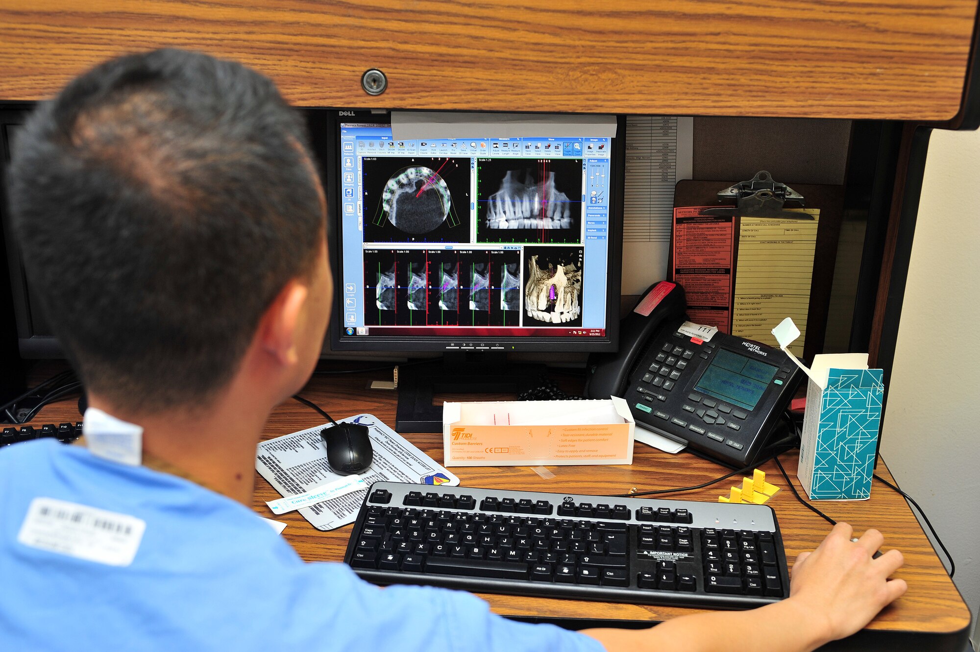 U.S. Air Force Capt. Kun-Jang Chang, 355th Dental Squadron chief of periodontics, reviews a cone beam Computerized Tomography scan for implant surgical treatment. The dental clinic can perform these types of procedures using state of the art equipment to ensure the highest quality of treatment for patients. (U.S. Air Force photo by Airman 1st Class Josh Slavin/Released)