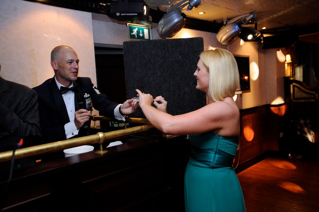RAF MENWITH HILL, United Kingdom - Master Sgt. Keith McKeeby, 451st Intelligence Squadron first sergeant, presents Elizabeth Craven with a door prize during the 501st Combat Support Wing Air Force Ball at the Community Club on RAF Menwith Hill. (U.S. Air Force photo by Staff Sgt. Brok McCarthy)