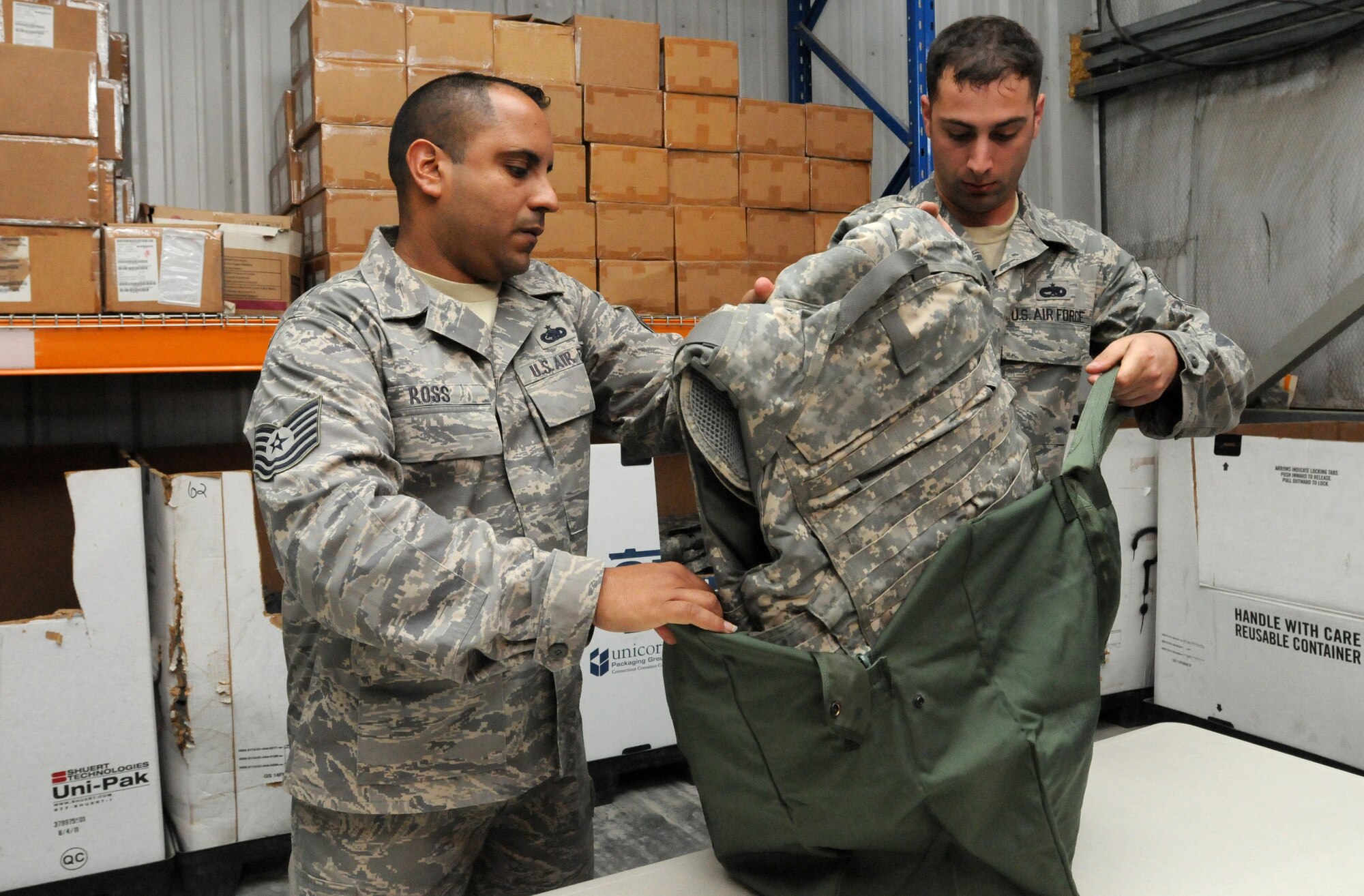 SOUTHWEST ASIA - U.S. Air Force Tech. Sgt. Jose Ross, 380th Expeditionary Logistics Readiness Squadron NCO in charge, helps Staff Sgt. Jason Shaffer, 380th Expeditionary Aircraft Maintenance Squadron member, put his improved outer tactical vest in a bag Sept. 22, 2012. Ross is deployed from Little Rock Air Force Base, La., and Shaffer is deployed from Royal Air Force Lakenheath, England. (U.S. Air Force photo/Tech. Sgt. Amanda Savannah)