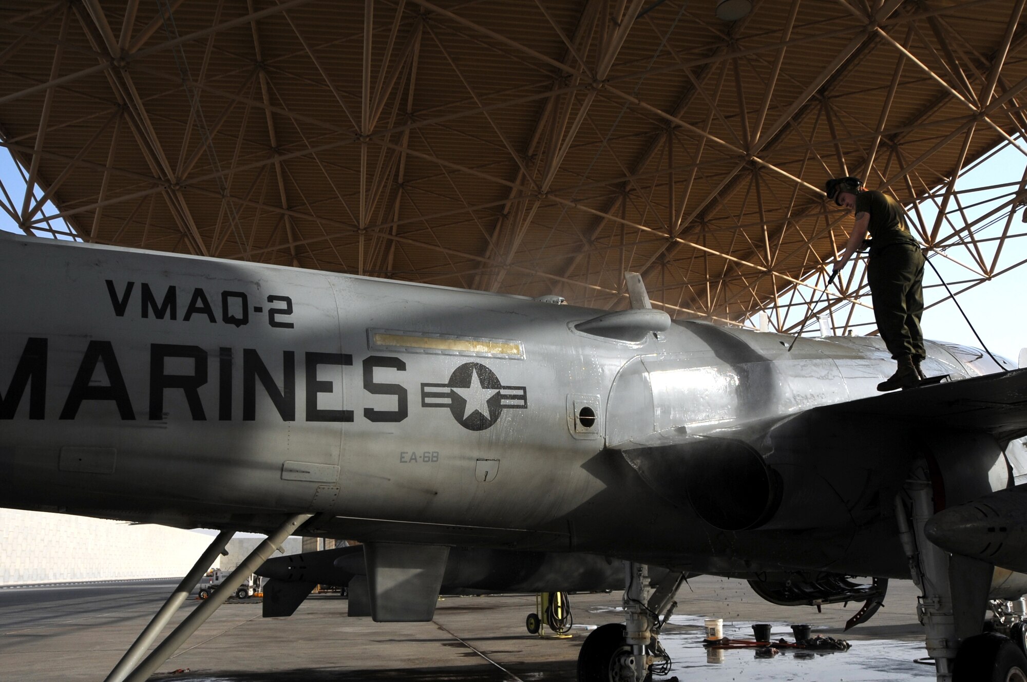 Cpl. Karl Schmid uses a high-pressure water spray to remove dirt and build-up residue on an EA-6B Prowler during a 14-day aircraft wash in Southwest Asia, September 25, 2012. The 14-day aircraft wash helps prevent corrosion build-up and can average up to four hours per aircraft. Schmid is assigned to the Marine Tactical Electronic Warfare Squadron Three, deployed from the Marine Corps Air Station Cherry Point, N.C. and a St. Louis native. (U.S. Air Force photo/Staff Sgt. Sheila deVera)