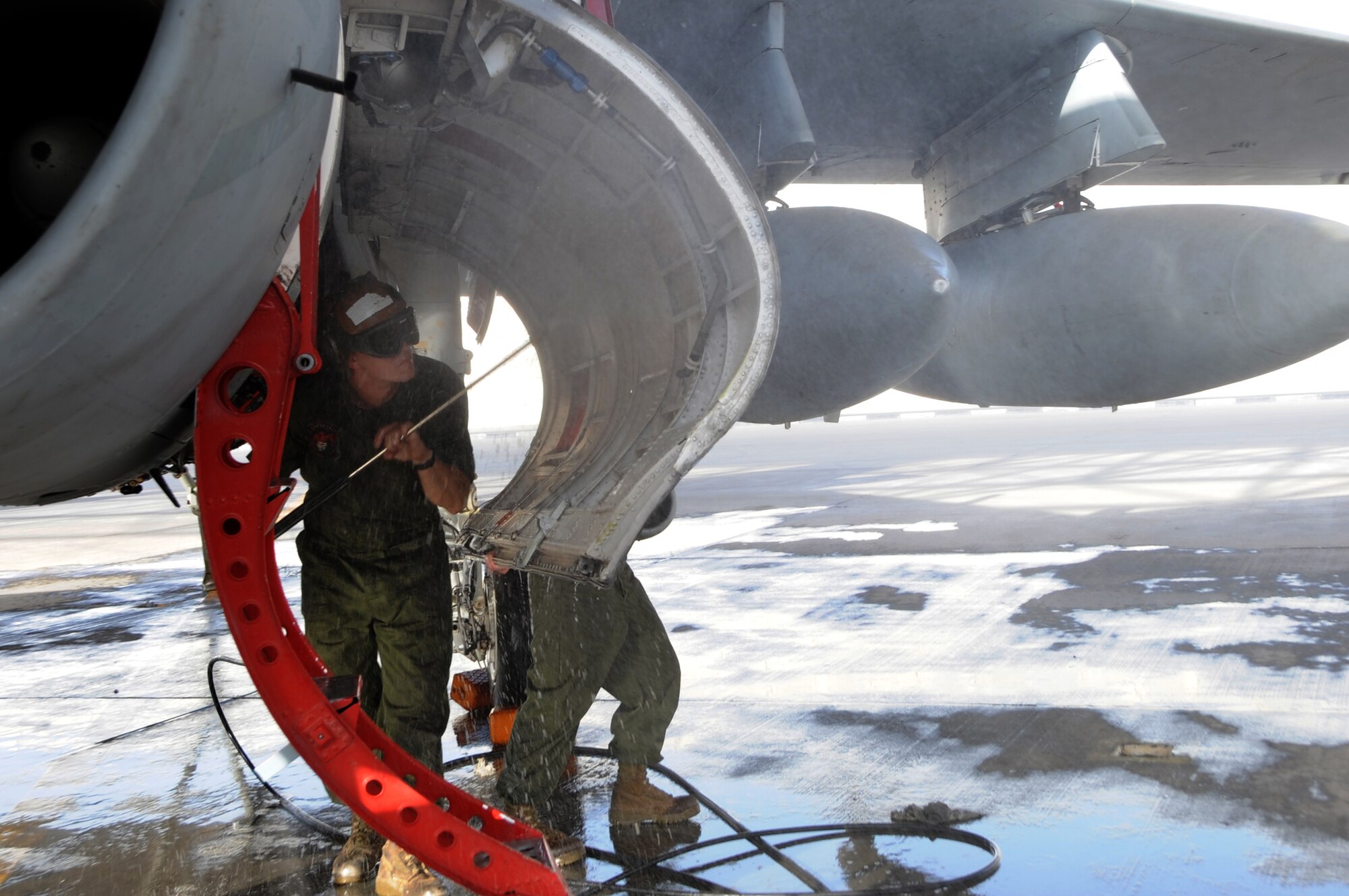 Cpl. Shelby Coville, Marine Tactical Electronic Warfare Squadron Three, uses a high-pressure water spray to remove dirt and build-up residue during a 14-day aircraft wash in Southwest Asia, September 25, 2012. Coville is deployed from the Marine Corps Air Station Cherry Point, N.C. and is a native of Orderville, Utah. (U.S. Air Force photo/Staff Sgt. Sheila deVera)