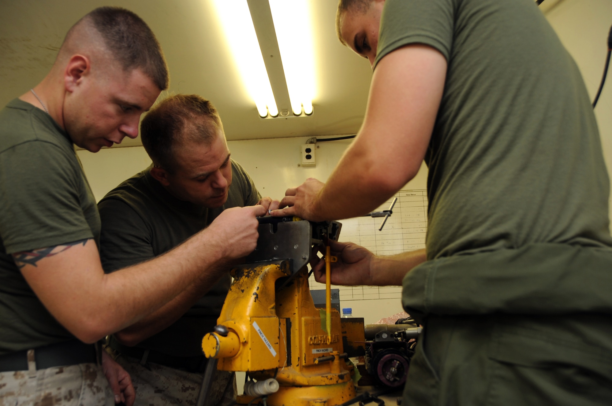 (Left to right) Cpl. Zachary Willard, Sgt. Trey Thomasee, Lance Cpl. Clayton Barker, perform an operational check on an EA-6B Prowler ejection seat part during a 364 inspection in Southwest Asia, September 25, 2012. The 364 day inspection is the most comprehensive inspection on the Prowler requiring numerous components to be taken apart and inspected for discrepancies. Willard, Thomasee and Barker are assigned to the Marine Tactical Electronic Warfare Squadron Three.  (U.S. Air Force photo/Staff Sgt. Sheila deVera)
