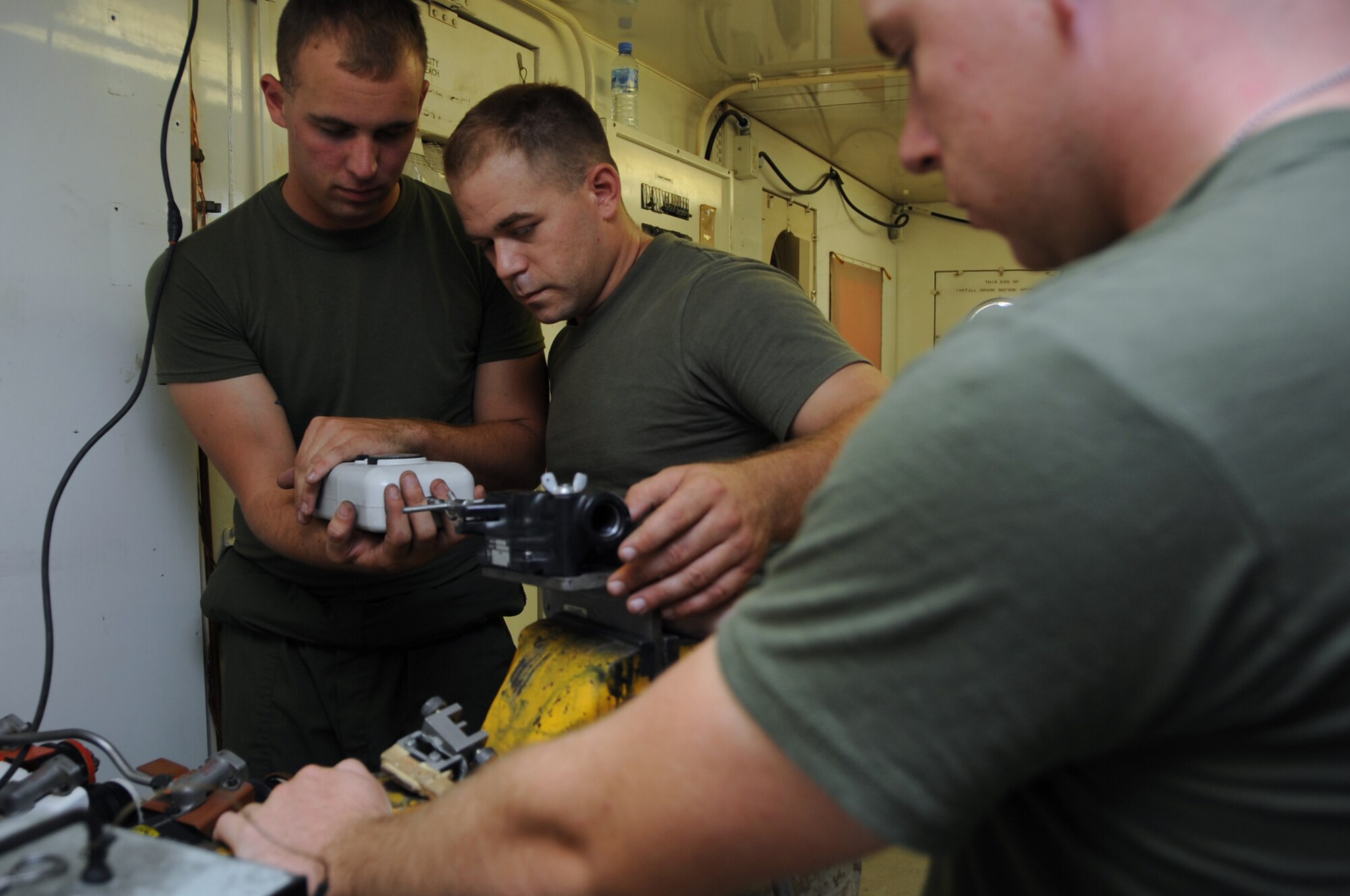 (Left to right) Lance Cpl. Clayton Barker, Sgt. Trey Thomasee, and Cpl. Zachary Willard, perform an operational check on an EA-6B Prowler ejection seat during a 364 day inspection in Southwest Asia, September 25, 2012. The 364 day inspection is the most comprehensive inspection on the Prowler requiring numerous components to be taken apart and inspected for discrepancies. Barker, Thomasee and Willard are assigned to the Marine Tactical Electronic Warfare Squadron Three.  (U.S. Air Force photo/Staff Sgt. Sheila deVera)