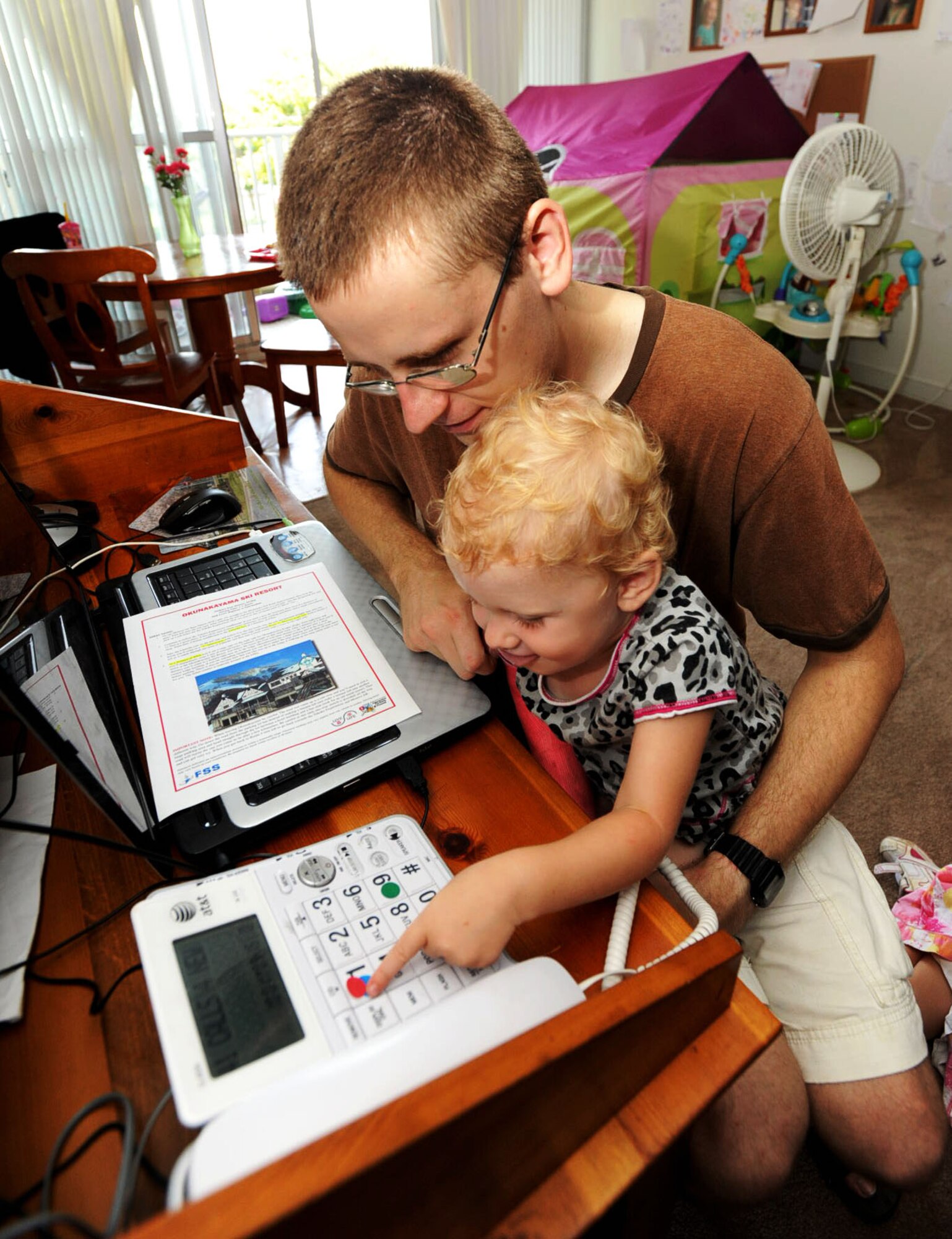 U.S. Air Force Airman 1st Class Michael Adams, 35th Civil Engineer Squadron emergency management apprentice, watches as his youngest daughter successfully simulates dialing 911 at Misawa Air Base, Japan, Sept. 15, 2012. Adams chose September to re-educate his children on preparing for natural disasters because the month of September is National Preparedness month. National Preparedness Month is an annual campaign to raise awareness on the importance of disaster preparedness. (U.S. Air Force photo by Airman 1st Class Kenna Jackson)