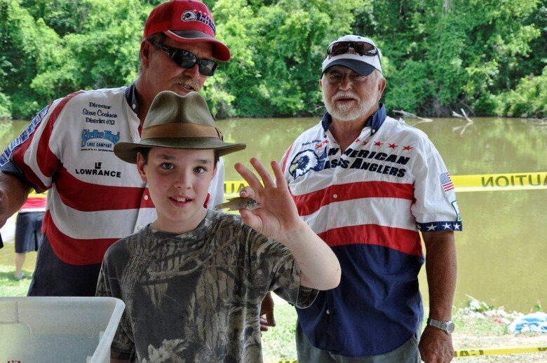 Nathan Blades, 10, proudly displays the 0.00-pound bream that earned him the trophy for smallest fish caught in the Cheatham Lake Fish Bustin’ Rodeo June 9, 2012. In the background are Steve Cochran, left, director of district 32, American Bass Anglers, and Bobby Robinson, assistant director, ABA which co-sponsored the event. (USACE photo by Fred Tucker)