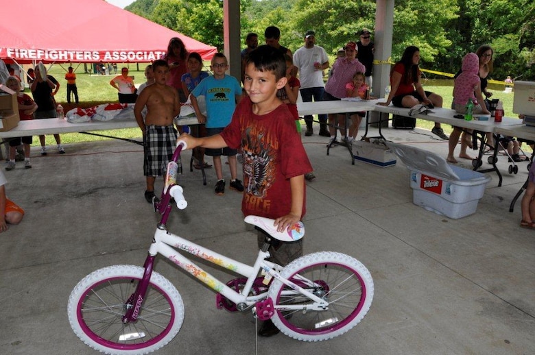 Evan Sproat, 9, proudly displays the bike he won in a drawing at the Cheatham Lake Fish Bustin’ Rodeo June 9, 2012 — after being assured that the generous sporting goods store that donated the bike would let him exchange it for another color. (USACE photo by Fred Tucker)
