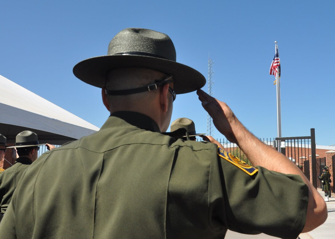 A Border Patrol agent salutes during the raising of the U.S. flag as part of the Sept. 18 dedication ceremony of the Brian A. Terry Border Patrol Station in Naco, Ariz. The U.S. Army Corps of Engineers Los Angeles District built the station which was named for the Border Patrol agent killed in the line of duty Dec. 15, 2010.  