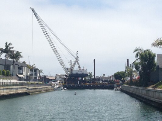 R.E. Staite’s dredge Palomar works in tight spaces alongside waterfront homes in Newport Harbor to remove sediment from channels, restoring safe navigation for boats using the harbor.