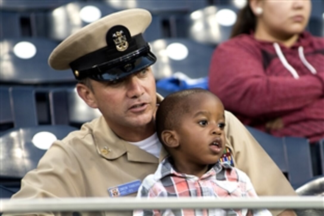 Navy Master Chief Fluvio Tamborini watches batting practice with his son before one of the last major league baseball games of the season between the San Diego Padres and the Los Angeles Dodgers at Petco Park in San Diego, Sept  25, 2012. Tamborini is assigned to Helicopter Sea Combat Squadron 85.