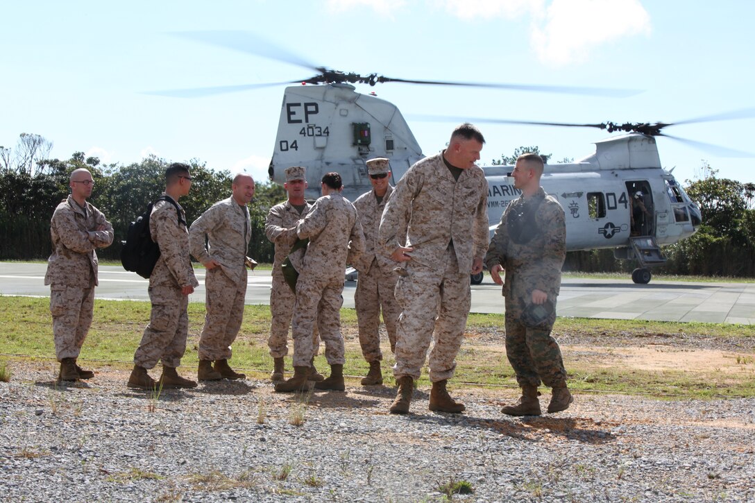 Brig. Gen. Niel E. Nelson, along with other distinguished visitors from the 3rd Marine Logistics Group, are greeted by Capt. Thomas A. Carpenter as they disembark a CH-46 Sea Knight helicopter at Camp Gonsalves Sept. 12. Nelson and the distinguished visitors traveled to the Jungle Warfare Training Center to observe Marines from 3rd MLG participate in the basic jungle skills course.  Nelson is the commanding general for 3rd MLG, III Marine Expeditionary Force, and Carpenter is the operations officer for Camp Gonsalves, Marine Corps Instillations Pacific. 