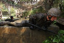 Lance Cpl. Brandon M. Hartsock keeps a low profile while exiting a portion of the pit and pond during the endurance course at the Jungle Warfare Training Center at Camp Gonsalves Sept. 12. The endurance course is the final portion of the eight-day basic jungle skills course offered at the Jungle Warfare Training Center. Hartsock is an ammunition technician with 3rd Supply Battalion, Combat Logistics Regiment 35, 3rd Marine Logistics Group, III Marine Expeditionary Force. 