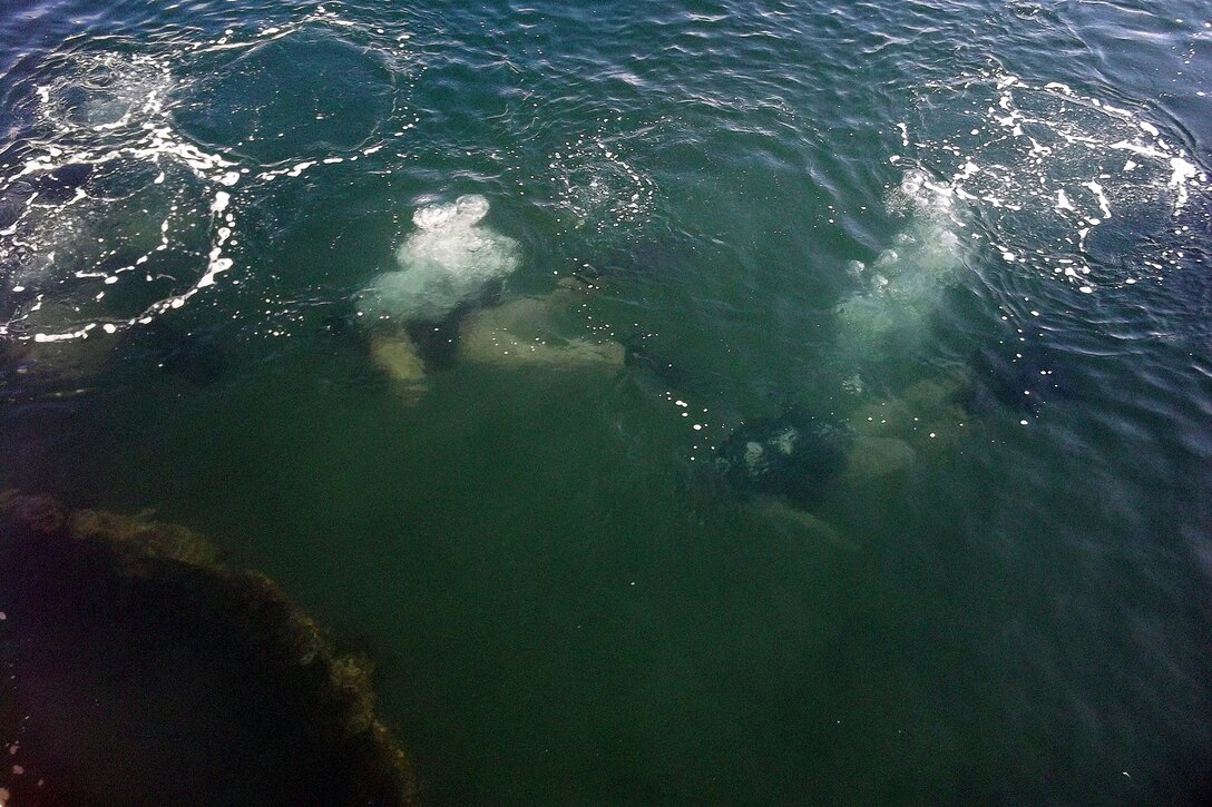 Marines with Reconnaissance Platoon, Battalion Landing Team 3/5, 15th Marine Expeditionary Unit, and Force Reconnaissance Platoon, 15th MEU, arrive at the USS Arizona Memorial before diving to see the sunken vessel, Sept. 19. The swift, silent and deadly divers used the time to sharpen their skills and qualify for some of the unique missions the Marines could be called upon to conduct during the deployment. They viewed USS Arizona Memorial from a unique vantage point of the and simultaneously earned an open-circuit dive qualification. An open-circuit dive is similar to recreational diving since the Marines use oxygen tanks.