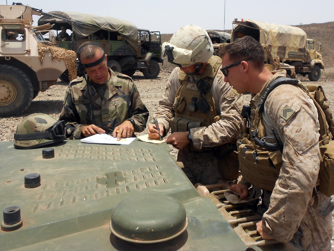 DJIBOUTI (Aug. 27, 2012) – Staff Sgt. Anthony Charette, right, and 1st Lt. Alexander Kowaleuski, the platoon sergeant and platoon commander, respectively, of Guns Platoon, India Battery, Battalion Landing Team 1st Battalion, 2nd Marine Regiment, 24th Marine Expeditionary Unit, discuss a convoy brief with a French Marine  during a bilateral training exercise in Djibouti, Aug. 27, 2012. Both nations spent Aug. 25-27 strengthening alliances and discussing tactics and procedures for the U.S. Marine Corps version of the French mortar, the M-327 120 mm Expeditionary Fire Support System, or EFSS. The 24th MEU, along with the Iwo Jima Amphibious Ready Group, is currently deployed to the U.S. Central Command and 5th Fleet areas of responsibility serving as a theater reserve providing support for maritime security operations and theater security cooperation efforts. (Courtesy photo by U.S. Marine Corps)