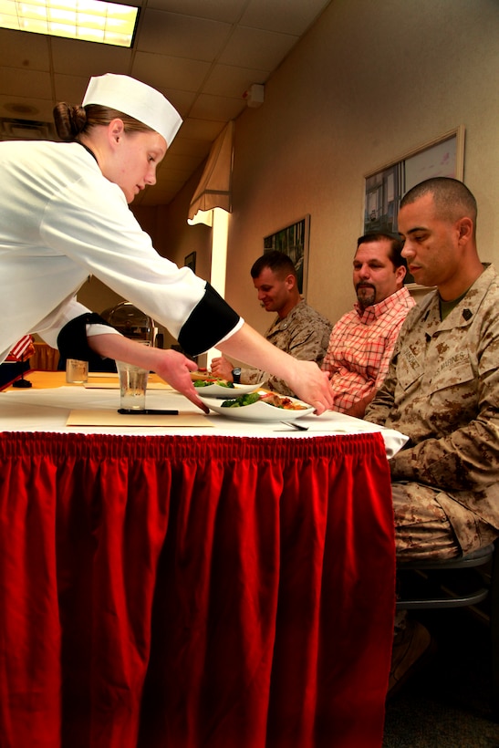 MARINE CORPS AIR STATION CHERRY POINT, N.C. – Lance Cpl. Andrea Blankenship, a food service specialist with Marine Wing Support Squadron 271, serves her lasagna and baked potato plate to judges of the Chef of the Quarter competition at the Cherry Point Mess Hall Sept. 20. Blankenship’s theme was “a homemade meal.”

