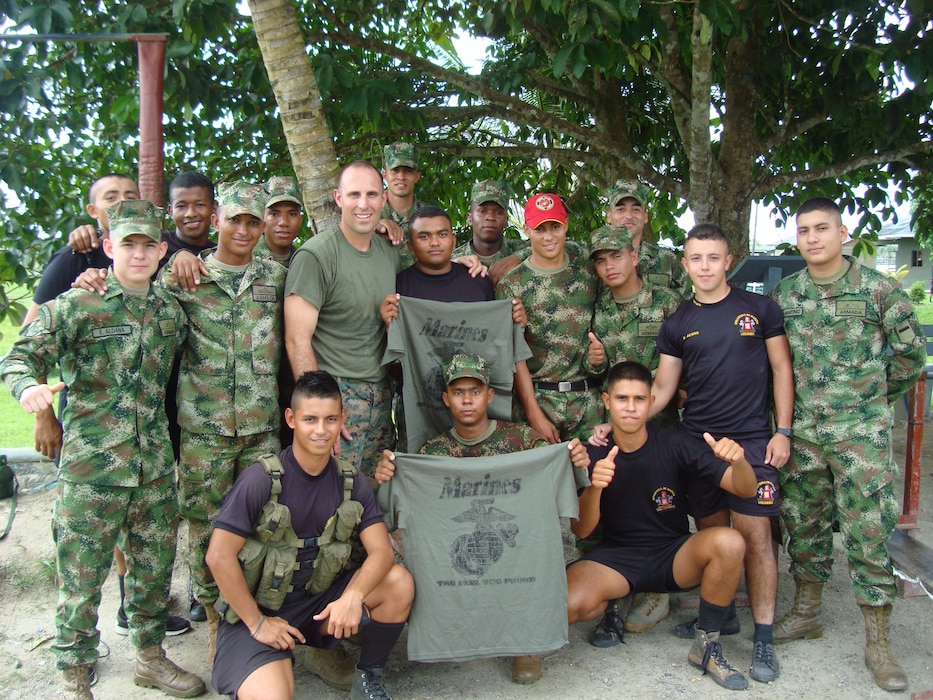 Maj McCormack, a Lat Am FAO conducting a utilization tour in Colombia, visits a riverine post and presents USMC shirts and hats to the winners of a PT competition