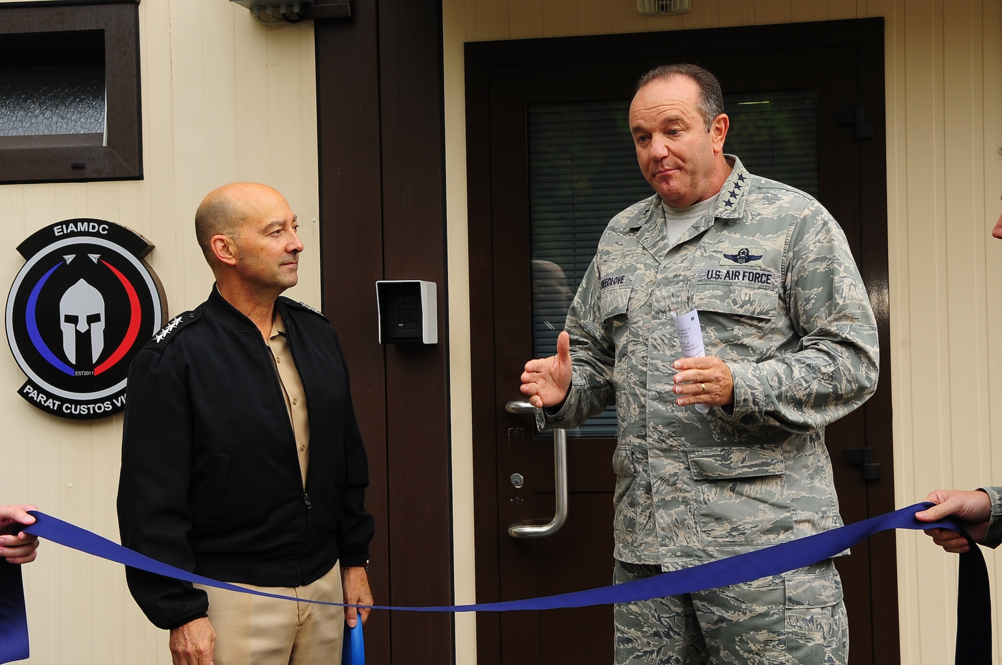 Admiral James Stavridis, Supreme Headquarters Allied Powers Europe commander, (left) looks on, as Gen. Philip M. Breedlove, Allied Air Command Ramstein commander, addresses NATO and senior leaders prior to the European Integrated Air and Missile Defense Center ribbon-cutting ceremony Sept. 26, 2012. The EIAMDC addresses increased education and training requirements driven by a new approach to missile defense and the emerging NATO territorial ballistic missile defense mission. (U.S. Air Force photo/Tech. Sgt. Tyrona Lawson)