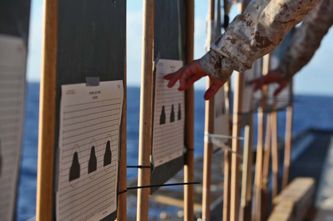 Servicemembers from Combat Logistics Battalion 15, 15th Marine Expeditionary Unit, check their shot patterns on targets on the flight deck of the USS Rushmore, Sept. 27. During the 15th MEU and Peleliu Amphibious Ready Group’s Western Pacific deployment, the Marines and sailors decided to let loose a few rounds in order to find their battle sight zero and ensure their M16A4 and M4A1 service rifles were functioning properly.
