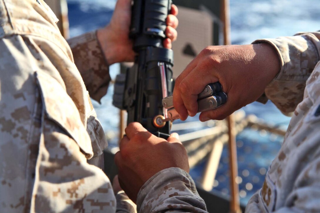 Staff Sgt. Aaron Weakley, utilities chief, Engineer Detachment, Combat Logistics Battalion 15, 15th Marine Expeditionary Unit, adjusts a Marine’s rifle-common-optic on the flight deck of the USS Rushmore, Sept. 27. During the 15th MEU and Peleliu Amphibious Ready Group’s Western Pacific deployment, the Marines and sailors decided to let loose a few rounds in order to find their battle sight zero and ensure their M16A4 and M4A1 service rifles were functioning properly. Weakley, 20, is from Elyria, Ohio. 