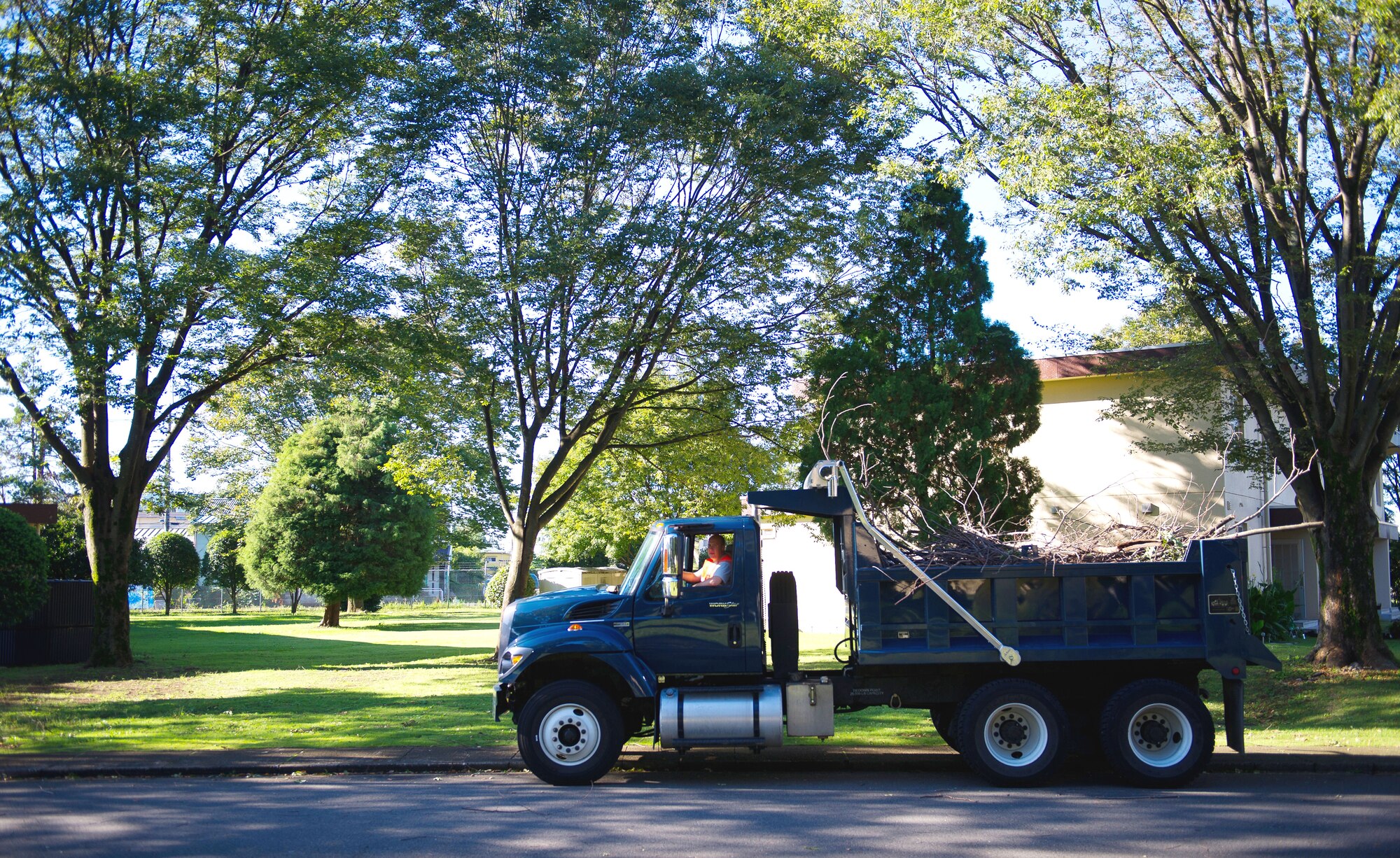 YOKOTA AIR BASE, Japan -- A 374th Civil Engineer Squadron truck waits as recovery crews load it with fallen tree branches during the recovery phase of Typhoon Jelawat at Yokota Air Base, Japan, on Oct. 1, 2012. After passing over the base, the typhoon was expected to gain strength as it continued over mainland Japan. (U.S. Air Force photo by Staff Sgt. Chad C. Strohmeyer)