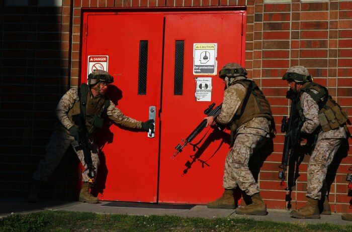 Marines prepare to breach a door at 2nd Maintenance Battalion, 2nd Marine Logistics Group’s compound aboard Camp Lejeune, N.C., during a training exercise March 27, 2013. The battalion equipped its Marines with the Multiple Integrated Laser Engagement System, which used lasers to simulate live ammunition during the event.