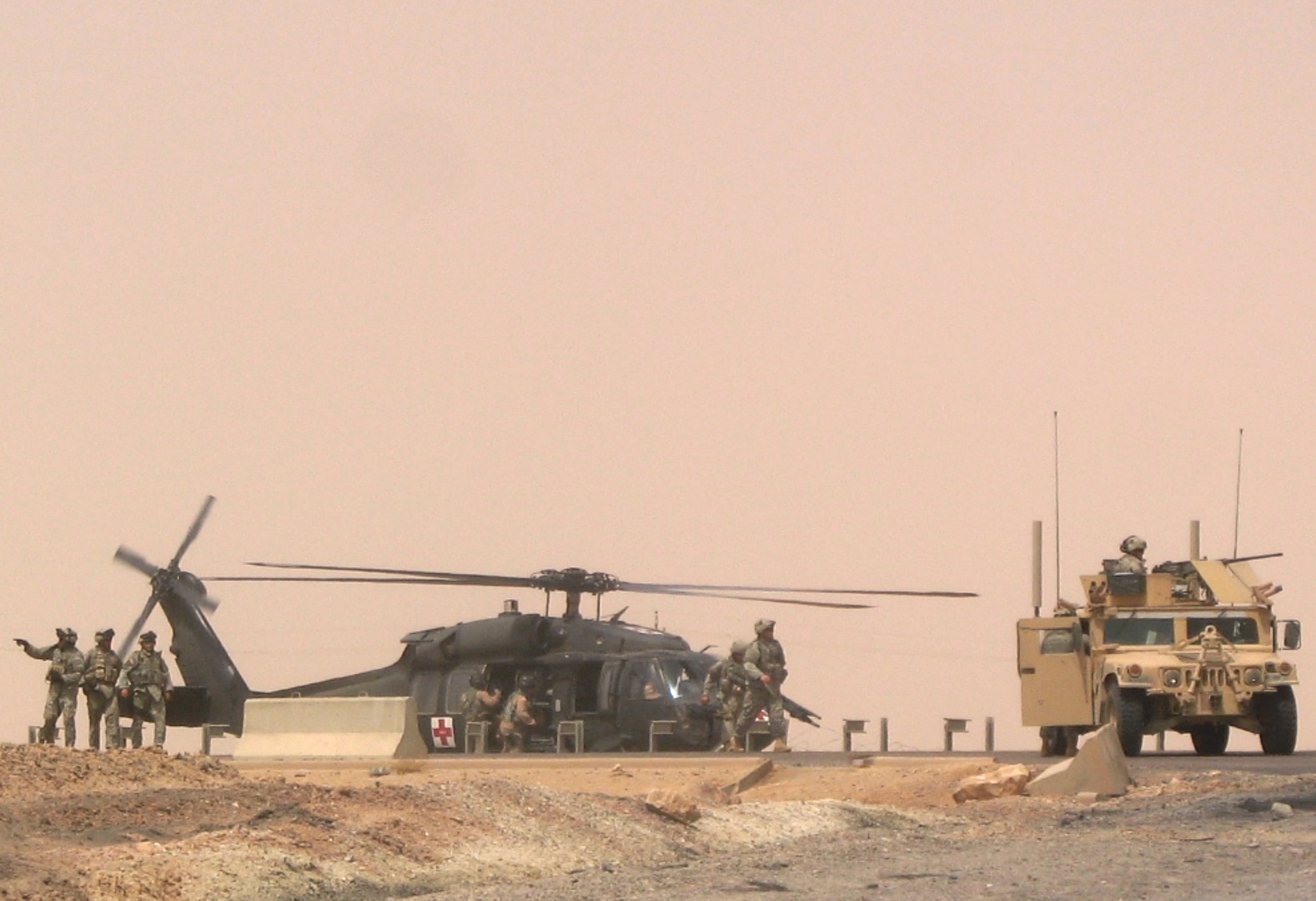 Members of the Mankato, Minn.-based 2nd Battalion, 135th Infantry Regiment survey the scene of a medical evacuation for three of their Soldiers after a Humvee in their convoy struck a pressure-plate improvised explosive device in the road Aug. 26, 2006. The IED was a 155 mm artillery shell.