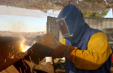 Oregon Army National Guard soldier, Sgt. Ross Willey of Portland, Ore., from Echo Company (Civil Engineer Unit), 3rd Battalion, 116th Calvary, based in Prineville, Ore., welds a railroad tie into place to create a vehicle barrier south of Sasabe, Ariz., on Jan. 19. Willey is working in Arizona as part of Operation Jump Start, supporting U.S. Customs and Border Patrol. The barriers will be used to prevent vehicles from illegally crossing the Arizona-Mexico border.