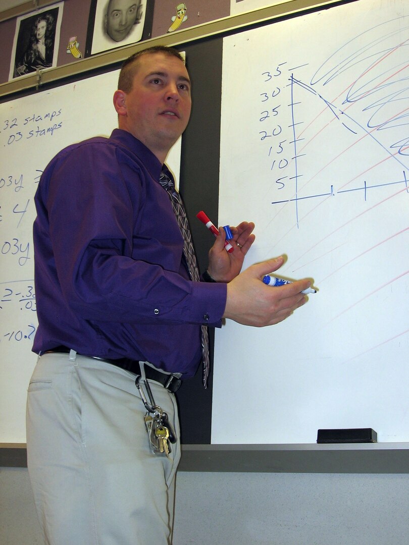 Henry D. Muren, a mathematics teacher at Barberton High School and a staff sergeant in the Ohio Army National Guard, explains a problem to his class while solving it on the board.