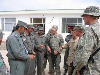 Army Sgt. Corey Virtue, center of Rapid City, S.D., Army Staff Sgt. Larry Walker, second from right of Custer, S.D., both members of 1st Platoon, 235th Military Police Company, and Air Force Senior Airman Justin Richardson, Bagram Provincial Reconstruction Team Afghan police training team member, talk about classes during a break here April 4. Police chiefs from seven districts across the Kapisa province received classroom instruction on ethics/values, leadership, community policing, map reading, running a tactical operations center, basic communication, hygiene and logistics. Completion of this course, April 2-4, made them the first Afghan police leaders to complete this type of training. (U.S. Air Force photo by)